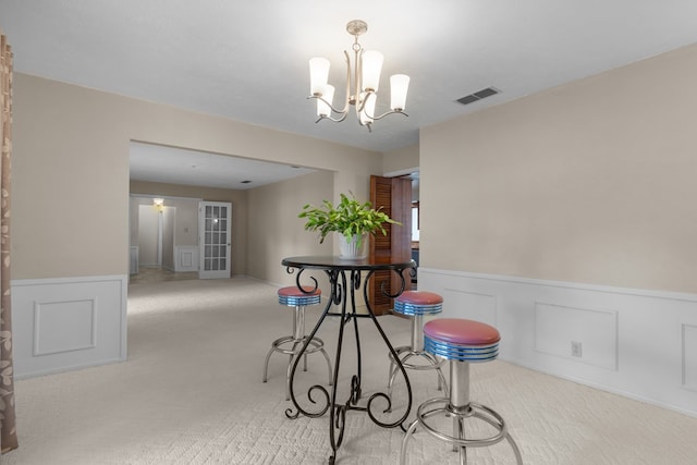 9408 Cromwell Ter, Odessa, TX 79764 - carpeted dining room featuring a chandelier, visible vents, and a wainscoted wall