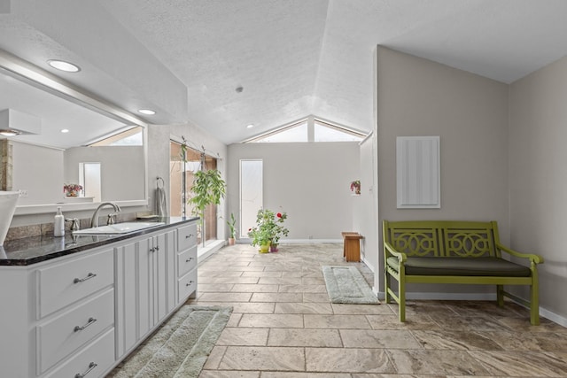 9408 Cromwell Ter, Odessa, TX 79764 - bathroom featuring recessed lighting, stone tile floors, baseboards, vanity, and vaulted ceiling