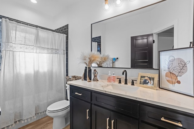 full bath featuring vanity, wood finished floors, toilet, and curtained shower