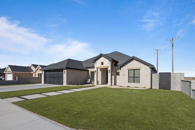 view of front of house featuring fence, stone siding, a front yard, an attached garage, and driveway