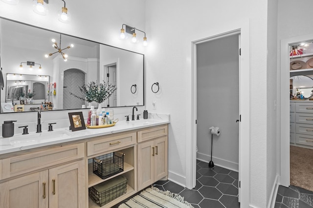 full bathroom featuring a sink, tile patterned flooring, double vanity, and a chandelier