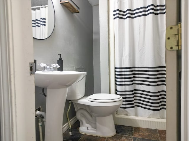 1431 S Alleghaney Ave, Odessa, TX 79761 - full bath featuring toilet, stone finish floors, a shower with curtain, a textured wall, and baseboards