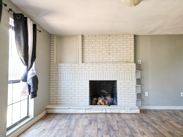 1431 S Alleghaney Ave, Odessa, TX 79761 - unfurnished living room with plenty of natural light, baseboards, and wood finished floors