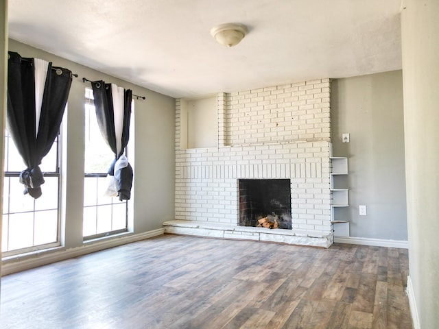 1431 S Alleghaney Ave, Odessa, TX 79761 - unfurnished living room with baseboards, wood finished floors, and a fireplace