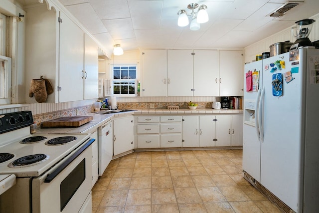 603 N 11th St, Alpine, TX 79830 - kitchen with white appliances, tile counters, white cabinetry, and vaulted ceiling