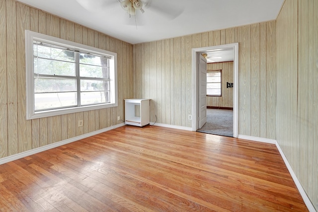 unfurnished room with ceiling fan, light wood-style floors, and baseboards