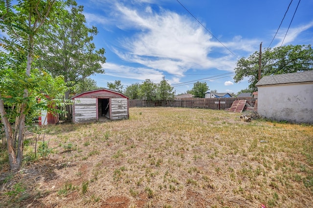 view of yard with fence, a shed, and an outdoor structure