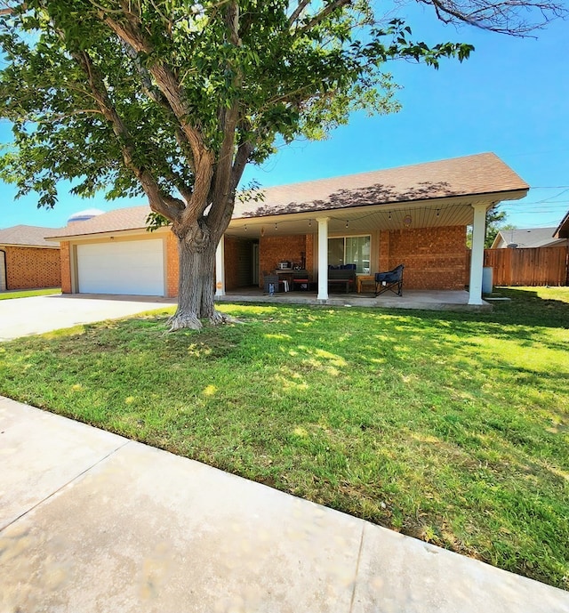 ranch-style home featuring fence, a front lawn, brick siding, a garage, and concrete driveway