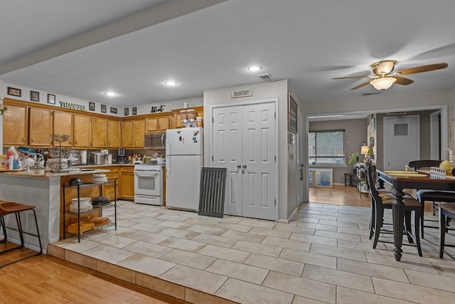 1306 Douglas Dr, Odessa, TX 79762 - kitchen featuring white appliances, brown cabinets, light countertops, a ceiling fan, and a peninsula