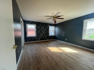 empty room featuring baseboards, ceiling fan, and wood finished floors