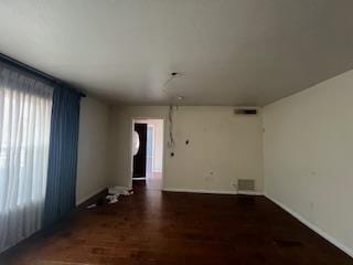 unfurnished room featuring visible vents and wood finished floors