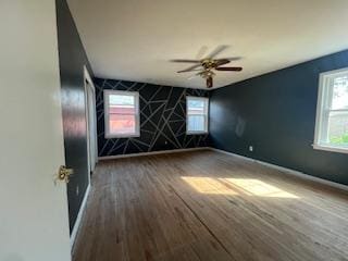 empty room featuring baseboards, ceiling fan, and wood finished floors