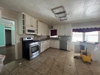 kitchen with stainless steel appliances, open shelves, decorative backsplash, and white cabinetry