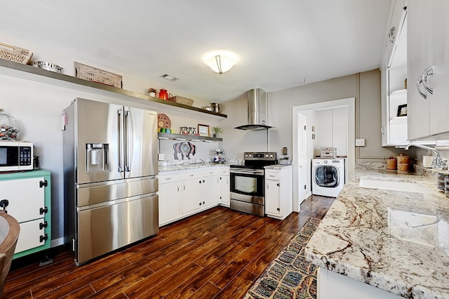 kitchen featuring light stone countertops, dark wood-type flooring, wall chimney range hood, washer / dryer, and appliances with stainless steel finishes