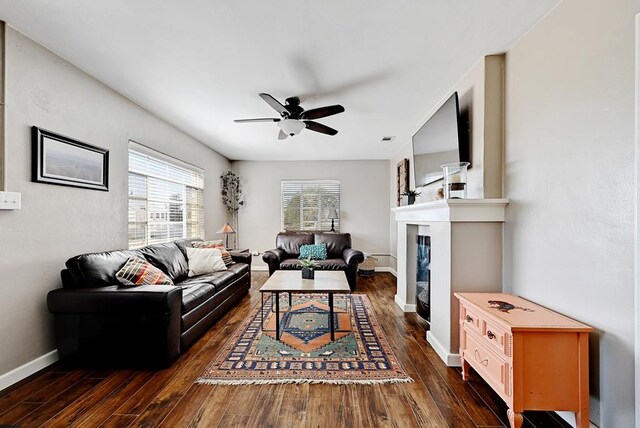 living room with ceiling fan and dark hardwood / wood-style flooring