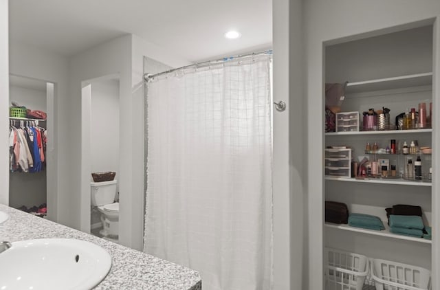 7018 Adenium Rd, Odessa, TX 79765 - full bathroom with double vanity, a walk in closet, and a shower with shower curtain