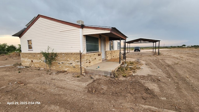 341 Bass St, Crane, TX 79731 - view of home's exterior featuring a carport, brick siding, and driveway