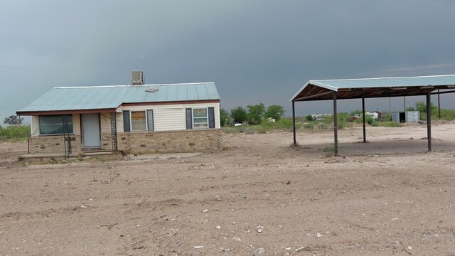341 Bass St, Crane, TX 79731 - view of front of house featuring brick siding, metal roof, and a carport