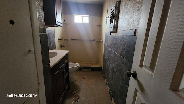 341 Bass St, Crane, TX 79731 - full bathroom featuring toilet, a stall shower, tile walls, and vanity