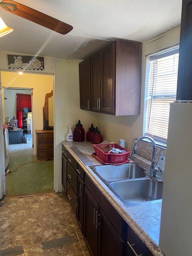 418 S Lee Ave, Odessa, TX 79761 - kitchen featuring a sink, freestanding refrigerator, dark brown cabinets, and light countertops
