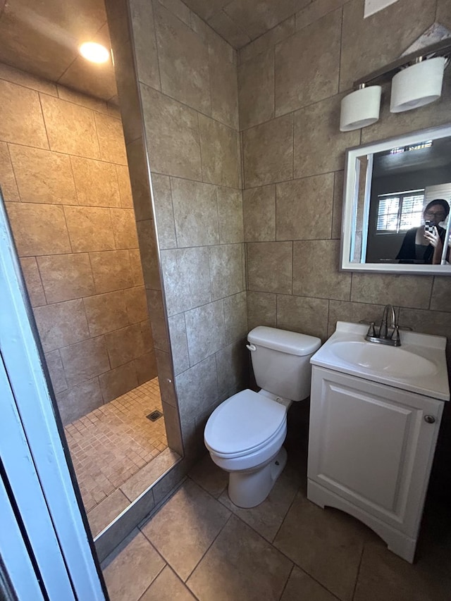 1712 Nabors Ln, Odessa, TX 79761 - bathroom with tiled shower, toilet, vanity, tile patterned floors, and tile walls