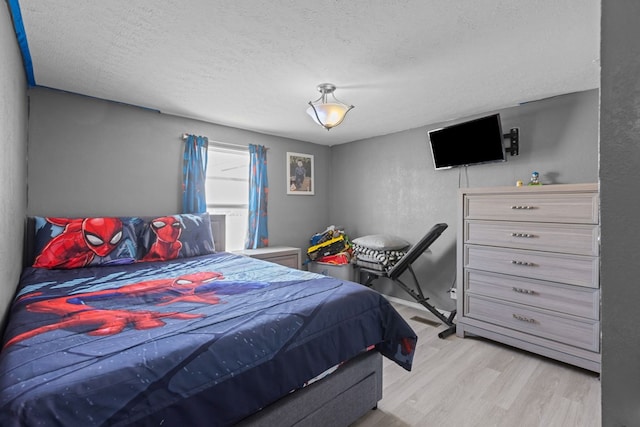 bedroom featuring a textured ceiling and wood finished floors