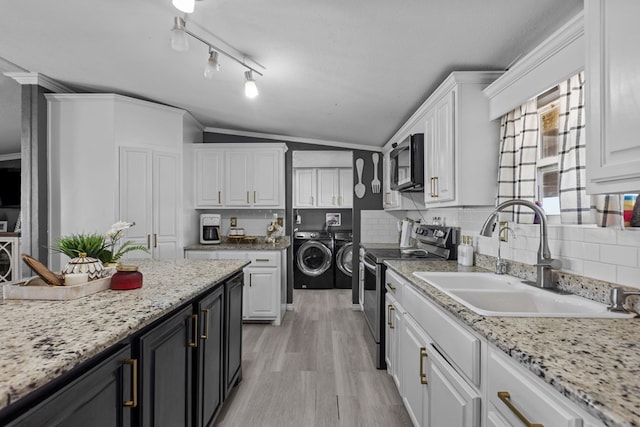 kitchen featuring white cabinetry, washer and clothes dryer, stainless steel appliances, and a sink