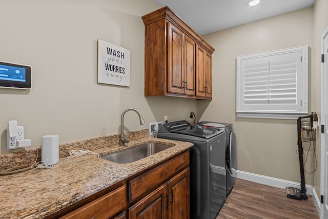 washroom with washing machine and clothes dryer, dark wood-type flooring, baseboards, and cabinet space