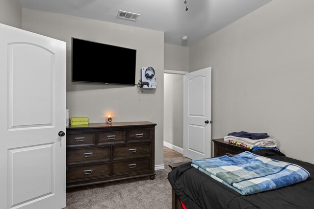 bedroom with light colored carpet and baseboards