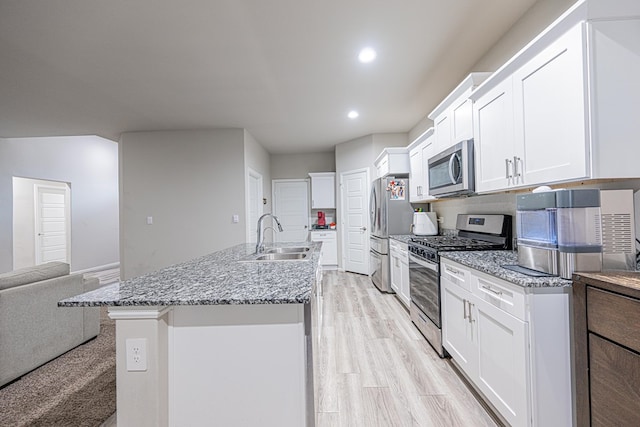 6205 Globe Life Ct, Odessa, TX 79762 - kitchen featuring appliances with stainless steel finishes, white cabinetry, recessed lighting, open floor plan, and a center island with sink