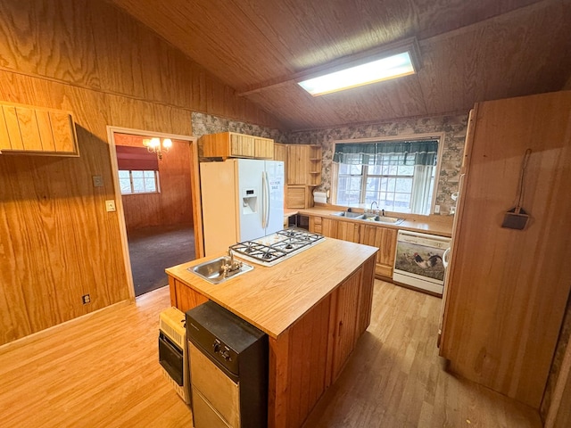 101 Stage Coach Pass, Fort Davis, TX 79734 - kitchen featuring white appliances, healthy amount of natural light, light wood-style floors, vaulted ceiling, and wallpapered walls