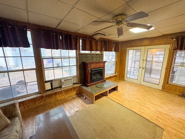 101 Stage Coach Pass, Fort Davis, TX 79734 - unfurnished living room with a ceiling fan, wood finished floors, a paneled ceiling, healthy amount of natural light, and a glass covered fireplace