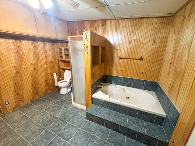 101 Stage Coach Pass, Fort Davis, TX 79734 - bathroom with a stall shower, tile patterned floors, a tub with jets, wood walls, and a ceiling fan