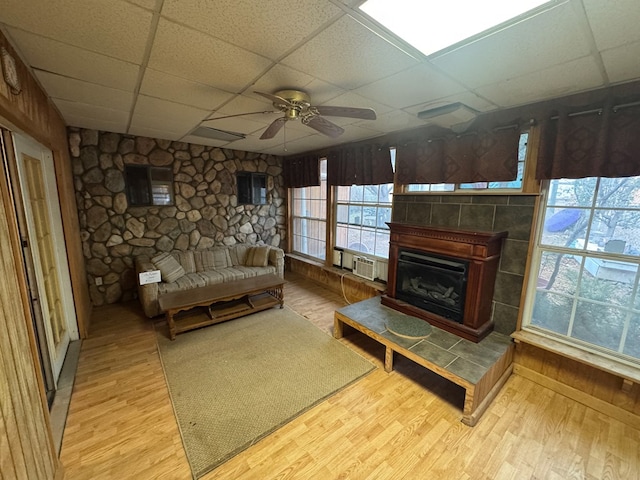 101 Stage Coach Pass, Fort Davis, TX 79734 - living room featuring a drop ceiling, a ceiling fan, wood finished floors, and a fireplace with raised hearth