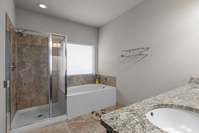 bathroom with a garden tub, vanity, and a stall shower