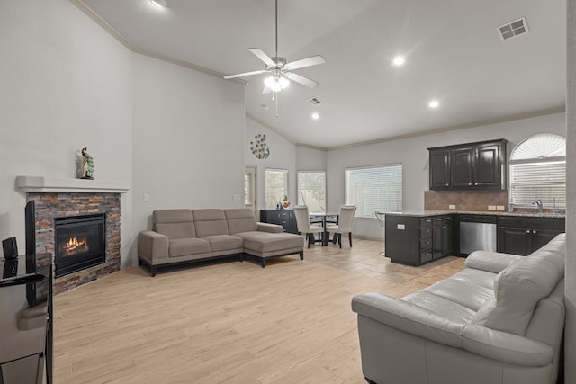 living room featuring a fireplace, visible vents, ceiling fan, ornamental molding, and recessed lighting
