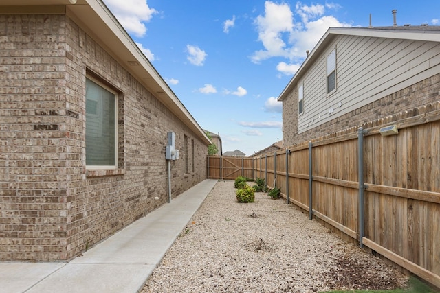 view of home's exterior with brick siding and a fenced backyard