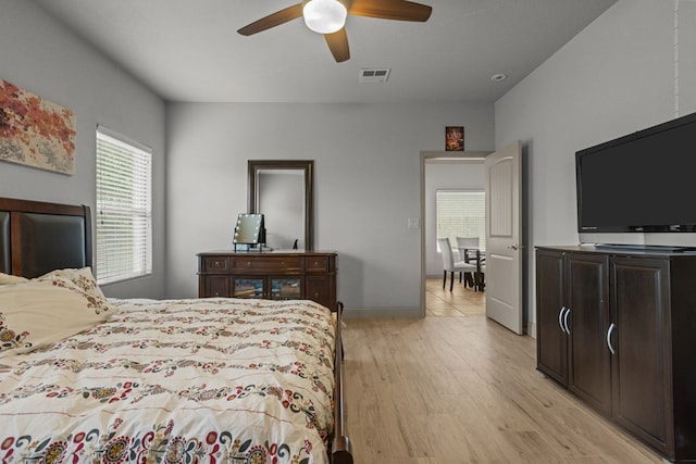 bedroom with ceiling fan, visible vents, and light wood-style floors