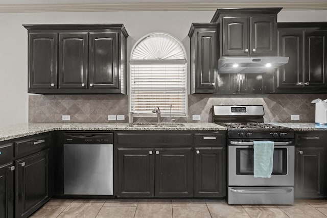 kitchen featuring under cabinet range hood, appliances with stainless steel finishes, dark cabinetry, and a sink