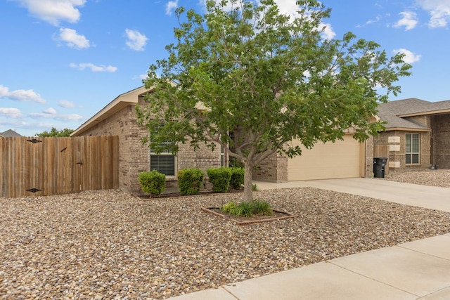 obstructed view of property with concrete driveway, brick siding, fence, and a garage