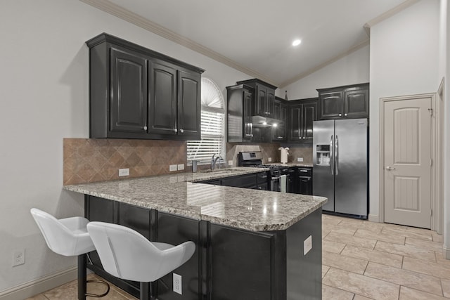 kitchen featuring a peninsula, dark cabinets, a sink, crown molding, and appliances with stainless steel finishes
