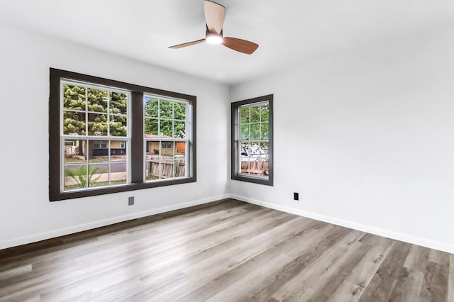spare room featuring baseboards, a ceiling fan, and wood finished floors