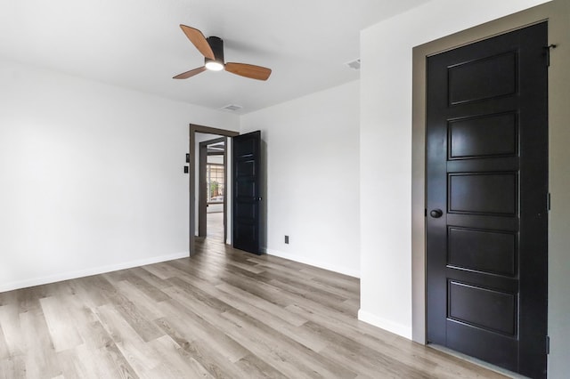 empty room with a ceiling fan, baseboards, visible vents, and light wood-type flooring