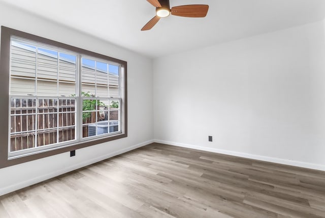 unfurnished room featuring baseboards, ceiling fan, and wood finished floors