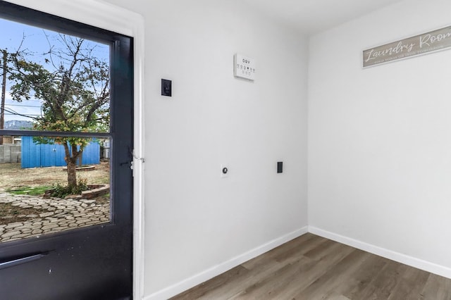 washroom featuring baseboards, electric dryer hookup, and wood finished floors