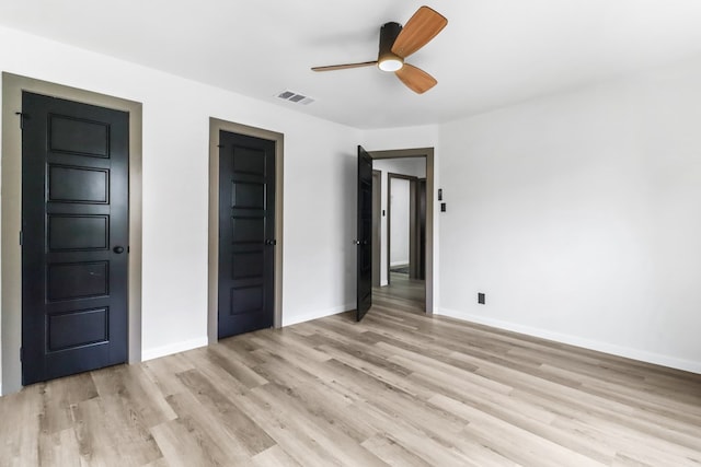 unfurnished bedroom featuring baseboards, visible vents, ceiling fan, and light wood-style floors