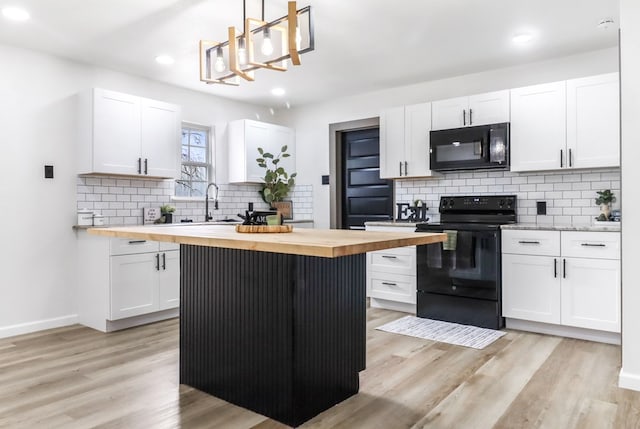 kitchen with wood counters, tasteful backsplash, black appliances, and white cabinets