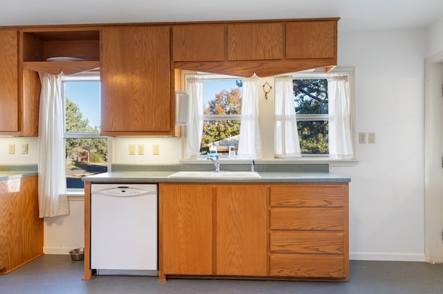 308 N 10th St, Alpine, TX 79830 - kitchen with dishwasher, a sink, baseboards, and brown cabinetry