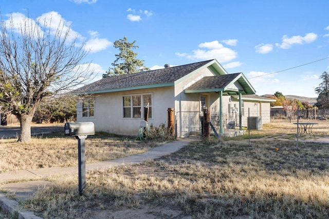 308 N 10th St, Alpine, TX 79830 - ranch-style house featuring stucco siding, fence, central air condition unit, a shingled roof, and a gate