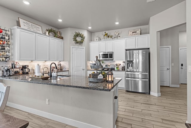 1215 E 93rd St, Odessa, TX 79765 - kitchen with stainless steel appliances, a peninsula, dark stone countertops, white cabinetry, and recessed lighting